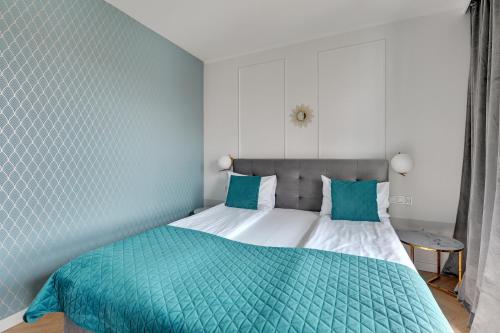 a bedroom with a bed with green and white sheets at GRANO APARTMENTS Gdańsk Old Town SPA & Wellness - GRANO APARTMENTS Gdańsk Residence SPA & Wellness in Gdańsk