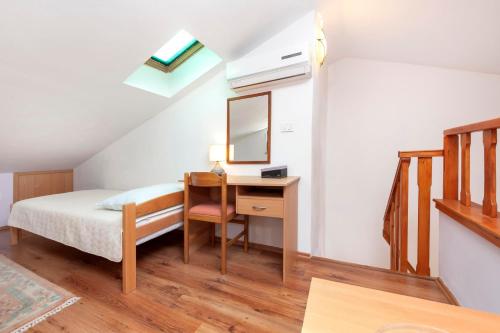 1 dormitorio con cama y escritorio con espejo en Apartments Adria en Rovinj