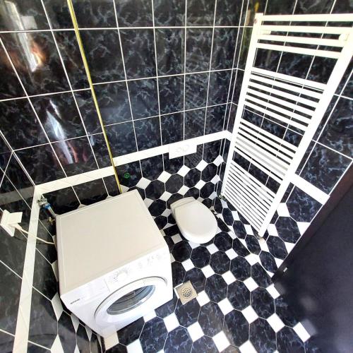 a bathroom with a toilet and a black and white tiled floor at Relax to the max with the sea view in Medulin
