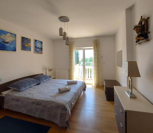a bedroom with a bed and a table and a window at Relax to the max with the sea view in Medulin