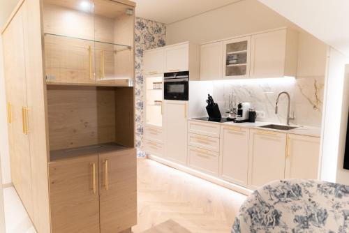 a kitchen with white cabinets and a sink at SCHLOSSRESIDENZ - Boutique Apartments & Hotel Suiten in Schloß Ricklingen