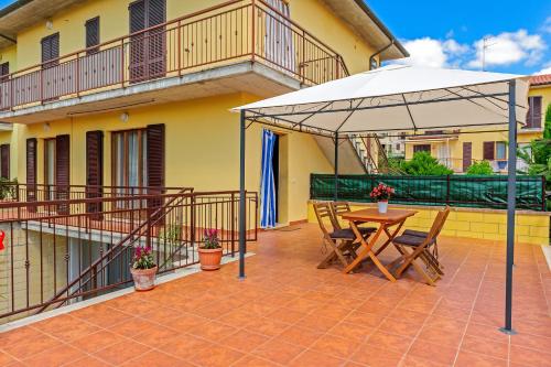 a patio with an umbrella and a table and chairs at Casa Leah in Montepulciano