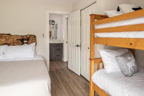 a bedroom with two bunk beds and a bathroom at Firelight Chalet 106 Candlelight Meadows in Big Sky