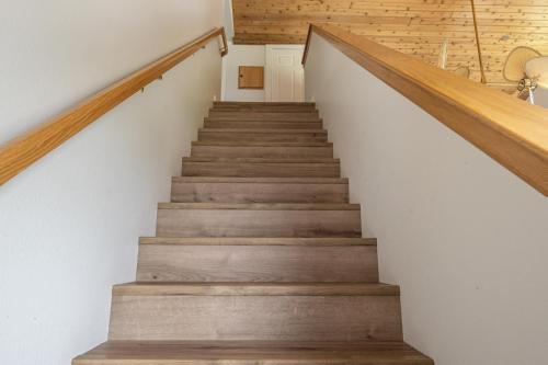 a staircase with wood treads and white walls at Firelight Chalet 106 Candlelight Meadows in Big Sky