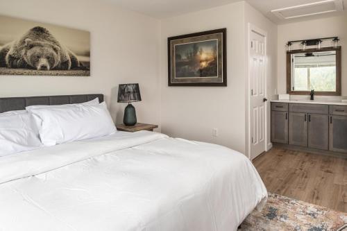a bedroom with a white bed and a sink at Firelight Chalet 106 Candlelight Meadows in Big Sky