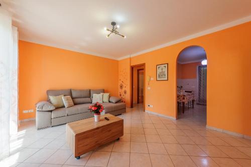 a living room with orange walls and a couch and a table at Casa Leah in Montepulciano