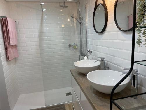 塞辛布拉的住宿－Sesimbra Balcony，白色的浴室设有2个盥洗盆和淋浴。
