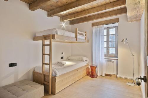 een slaapkamer met een houten stapelbed en een raam bij Luderna - Casa con terraza Codorna in Arties
