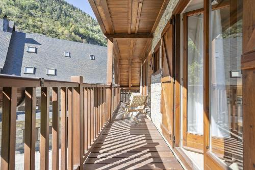 a wooden porch with a bench on the side of a building at Luderna - Dúplex Aiguamog in Arties