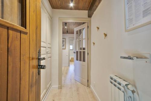 a hallway with a wooden door and a hallway with a hallway at Luderna - Dúplex Aiguamog in Arties