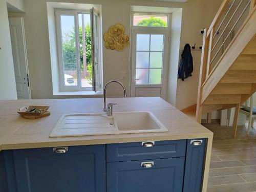 a kitchen with a sink and a staircase at Maison de campagne avec terrain in Vallon-en-Sully