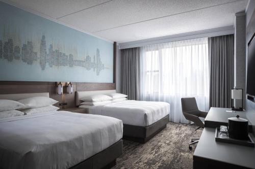 a hotel room with two beds and a desk at Courtyard by Marriott Chicago at Medical District-UIC in Chicago