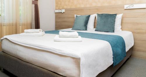 two beds in a hotel room with towels on them at Garni Hotel Mint in Belgrade