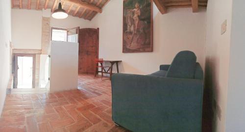 a living room with a green couch and a table at CasAlice Room&Breakfast in centro storico in Santarcangelo di Romagna