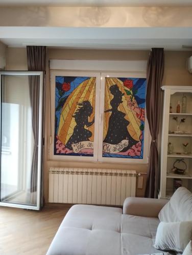 a living room with two stained glass windows at Lux Apartment Rose in Kragujevac