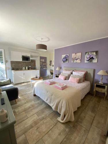a bedroom with a large bed with pink pillows at LES SANTOLINES - Studio à la campagne in Aigaliers
