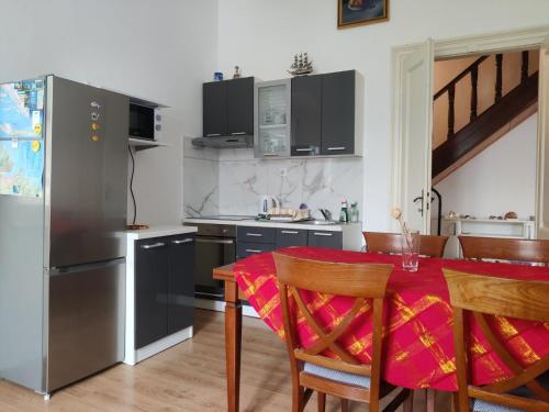 eine Küche mit einem Tisch und einem Kühlschrank aus Edelstahl in der Unterkunft Seafront apartment Marina2 in Jelsa