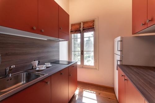a kitchen with a sink and a refrigerator at Villa Clementina - Prosecco Country Hotel in San Pietro di Feletto