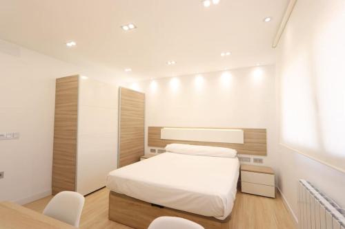 ベハルにあるApartamento LA BEJARANAの小さなベッドルーム(白いベッド1台、白い椅子付)