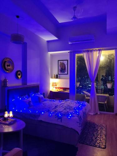 a purple bedroom with a bed with blue lights at Dubai Suite by Hey Studios in Ghaziabad