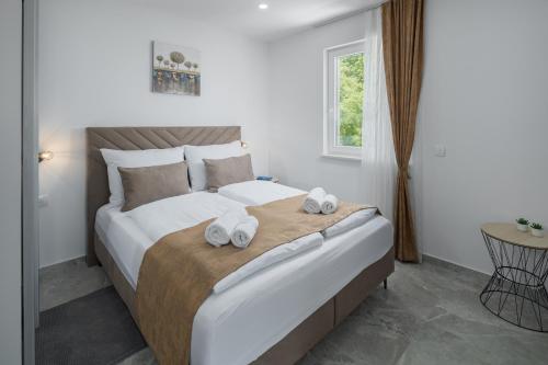 um quarto com uma cama grande e toalhas em Villa IN em Nova Vas
