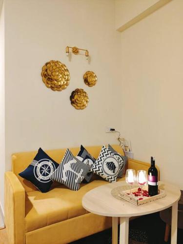 a living room with a yellow couch with pillows and a table at Dubai Suite by Hey Studios in Ghaziabad