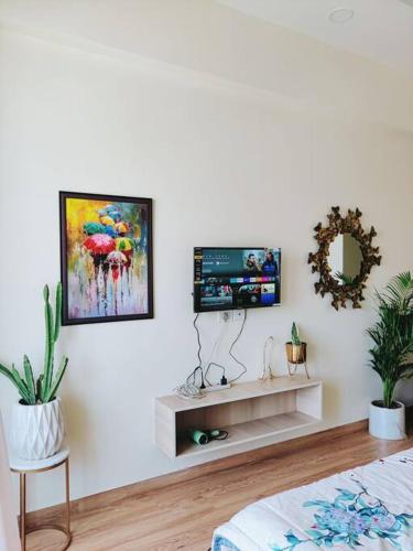a living room with a tv on a white wall at Dubai Suite by Hey Studios in Ghaziabad