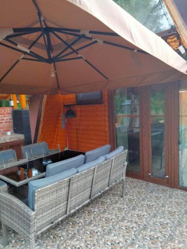 a patio with chairs and a large umbrella at Popasul Dacilor in Predeluţ