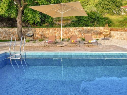a swimming pool with an umbrella and chairs and a table at Seaview Villa Lavanda with pool in Budva