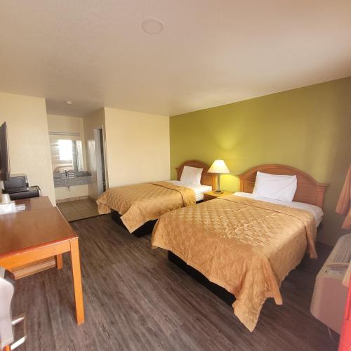 a hotel room with two beds and a desk at La Vista Motel in Brownsville