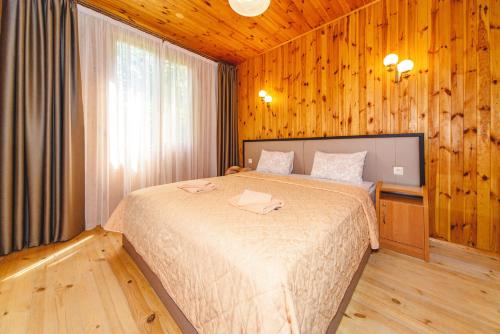 1 dormitorio con 1 cama grande en una habitación de madera en Sovinyon Resort, en Odessa