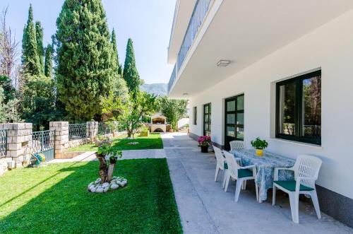 a patio with a table and chairs and grass at Apartments Garden in Cavtat