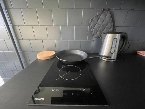 a frying pan on top of a stove in a kitchen at Dzīvoklis ar skatu pār Alūksni in Alūksne