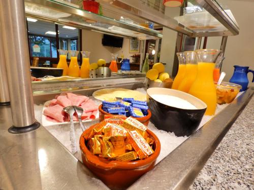 a kitchen with a counter with food and drinks at Hôtel du Parc Limoges & Restaurant "Le temps d'une pause" in Limoges