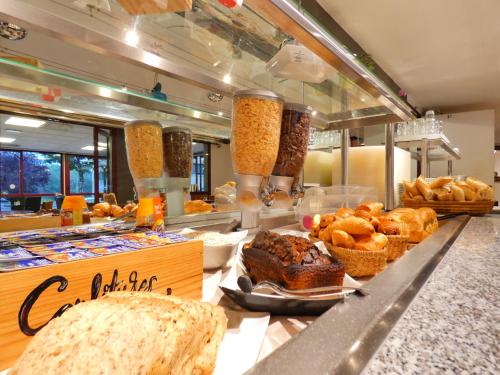 a bakery with bread and pastries on a counter at Hôtel du Parc Limoges & Restaurant "Le temps d'une pause" in Limoges