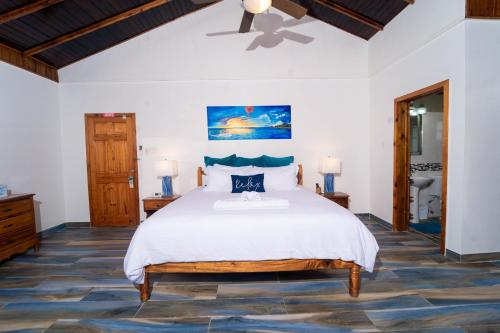 a bedroom with a large bed and a ceiling fan at Blue Skies Beach Resort in Negril