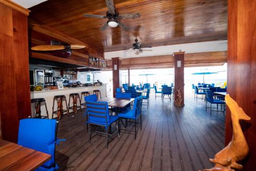 a dining room with blue chairs and a table at Blue Skies Beach Resort in Negril