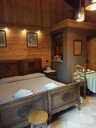 una camera da letto con un letto in una stanza di legno di L'Alpina Affittacamere a Bobbio Pellice