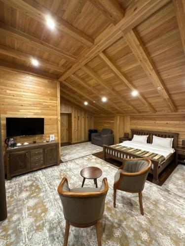 a bedroom with a bed and a tv and chairs at LE CHALET MONT And RESTAURANT in Chorwoq