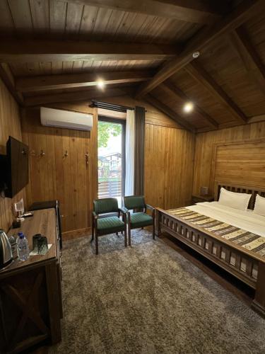 a bedroom with a large bed and two chairs at LE CHALET MONT And RESTAURANT in Chorwoq
