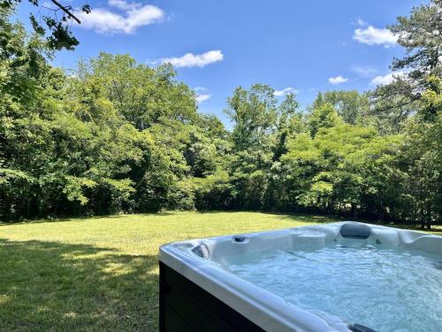 una vasca idromassaggio in un cortile con alberi sullo sfondo di A Mountain Cottage cabin a Sevierville