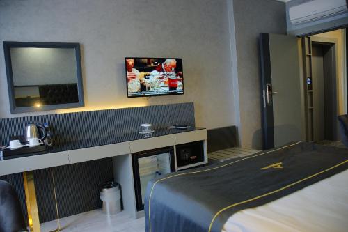 una camera d'albergo con letto e TV a parete di alfin otel a Ankara