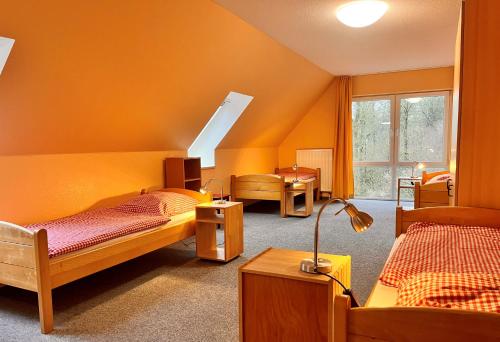 Habitación con 3 camas y lámpara. en Nordsee Jugendheim Delphin, en Husum