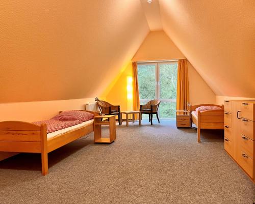 um quarto no sótão com 2 camas e uma janela em Nordsee Jugendheim Delphin em Husum