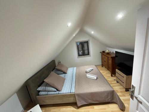 Dormitorio pequeño con cama y TV en La maison des camélias, en Le Tampon