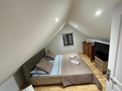 a small bedroom with a bed and a television at La maison des camélias in Le Tampon