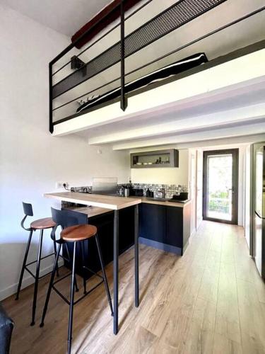 une cuisine avec un comptoir et des tabourets dans une pièce dans l'établissement Ravissant appartement à 5min du centre ville d'Aix, à Aix-en-Provence