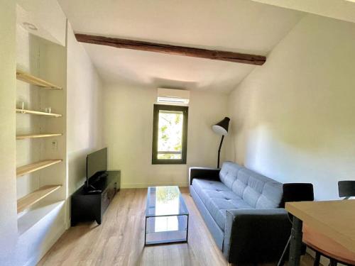 un salon avec un canapé bleu et une table dans l'établissement Ravissant appartement à 5min du centre ville d'Aix, à Aix-en-Provence