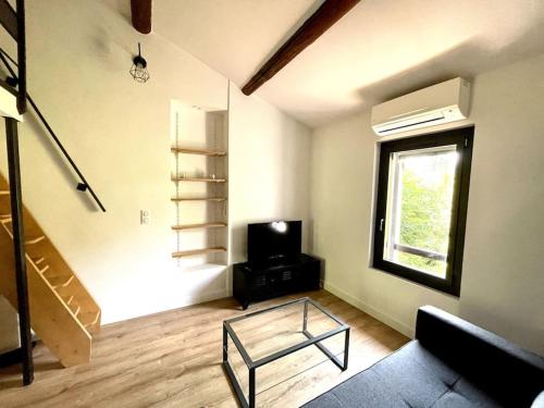 - un salon avec une table en verre et une télévision dans l'établissement Ravissant appartement à 5min du centre ville d'Aix, à Aix-en-Provence