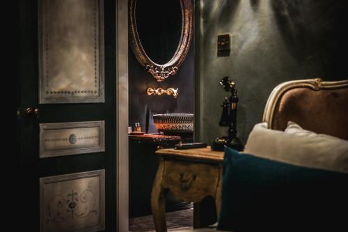a room with a bed and a mirror and a table at Le Petit Chateau & William de Percy in Otterburn